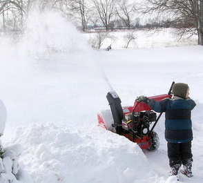 small boy using snowblower
