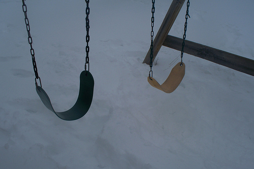 green and yellow swings over deep snow
