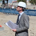 Dobrin Georgiev wearing hard hat and holding plans at construction site