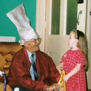 grandpa with chef hat laughing with granddaughter