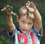 small boy showing muddy hands