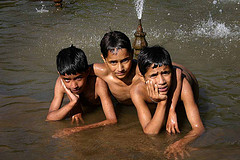 three boys on their bellies in water