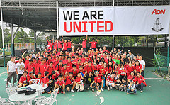 sports team posing together under sign that says We Are United