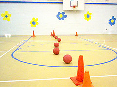 gymnasium with balls and cones set up in obstacle course