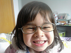 girl with glasses smiling at camera up close