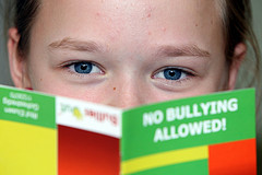 child reading book titled No Bullying Allowed