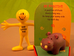 plastic toy saying God loves you, card saying Be Positive