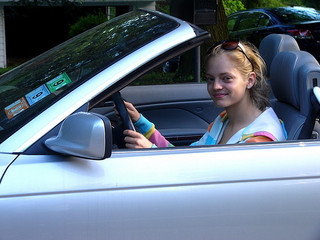 teen girl at wheel of blue car