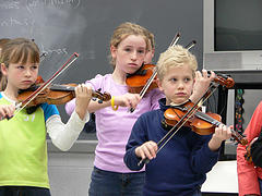 3 children practicing violin