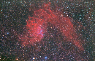 image of red nebula against black starry sky