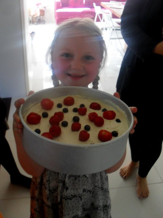 girl holding cheesecake with berries on top