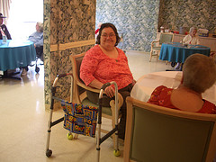 woman with walker in community room of nursing home