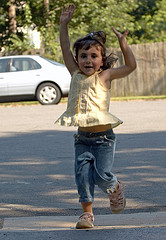 young girl finishing race, arms raised in triumph