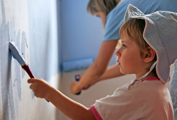 boy helping mom by painting wall
