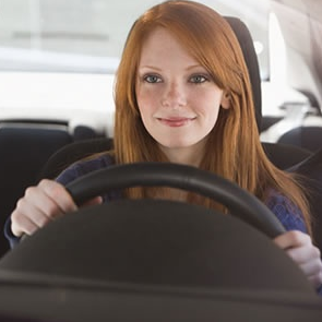 teen girl smiling while sitting in driver's seat