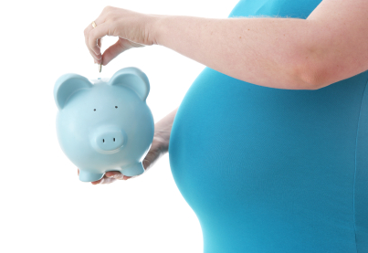 midsection of pregnant woman holding a piggy bank
