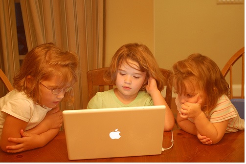 3 girls playing games on laptop computer