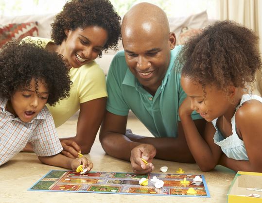 parents and 2 children playing board game