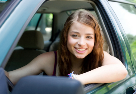 teen girl smiling from front of car