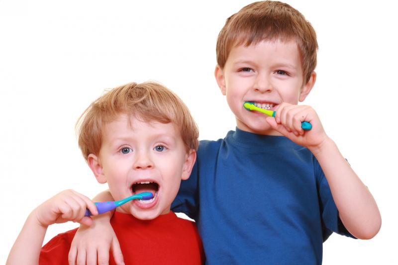 2 boys cheerfully brushing their teeth