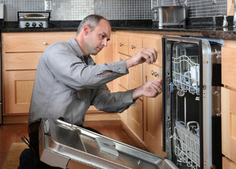 man working on installing a dishwasher